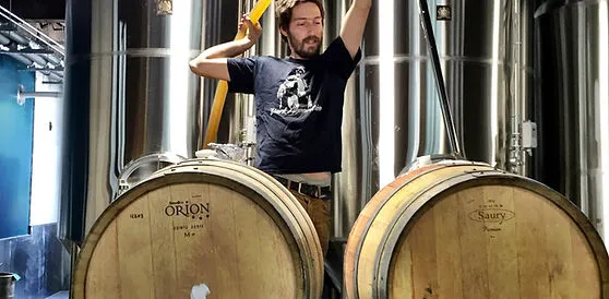 Brewing equipment and wood barrels inside a brewery.