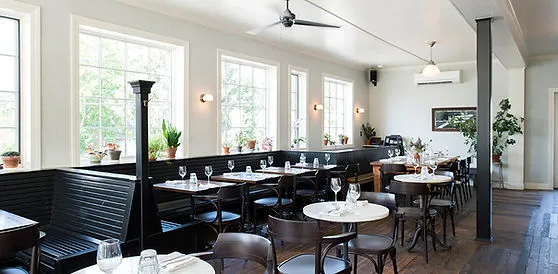 Bright, modern dining room with pendant lights and a bar.